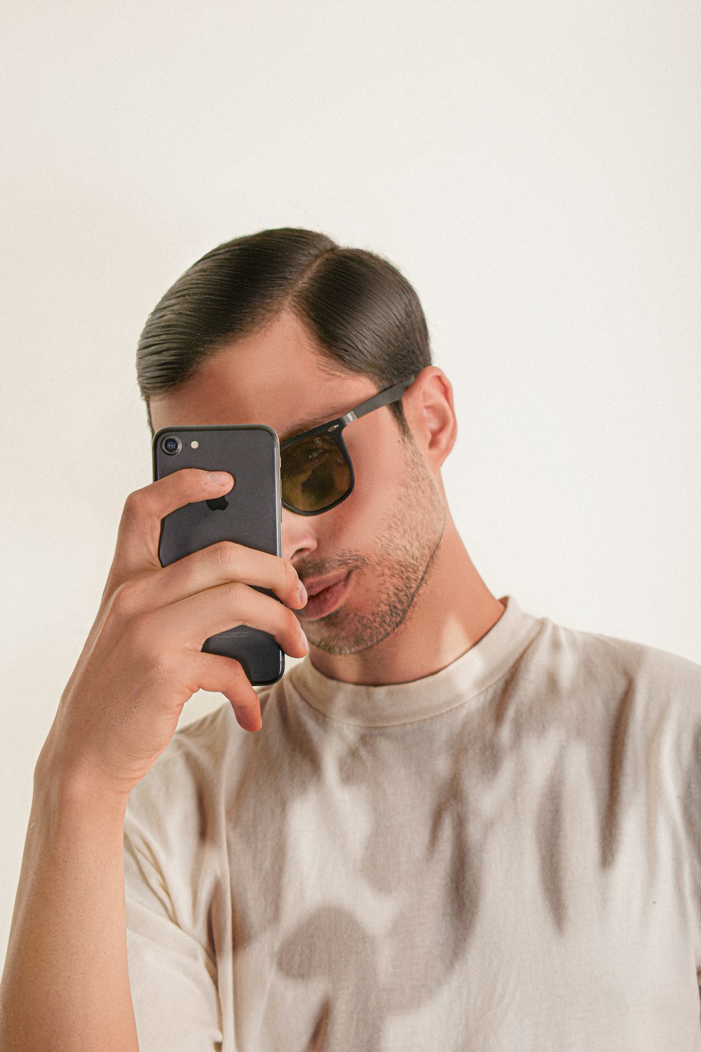 Un hombre con gafas de sol y sosteniendo un teléfono en la oreja