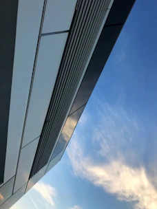 Commercial building with sleek navy and white facade under clear skies.