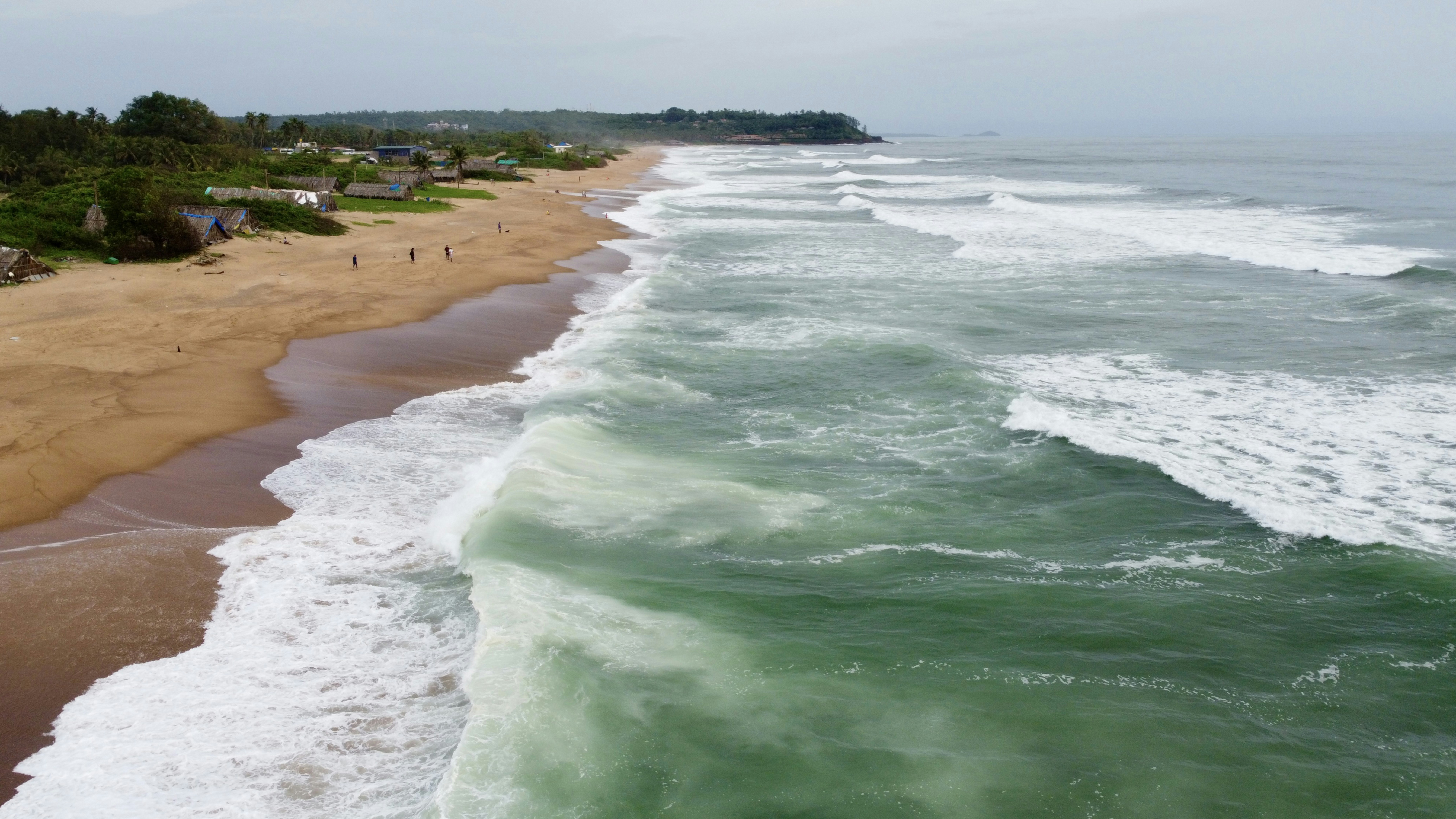 a beach with waves crashing on it, Powerful sea during monsoon season.