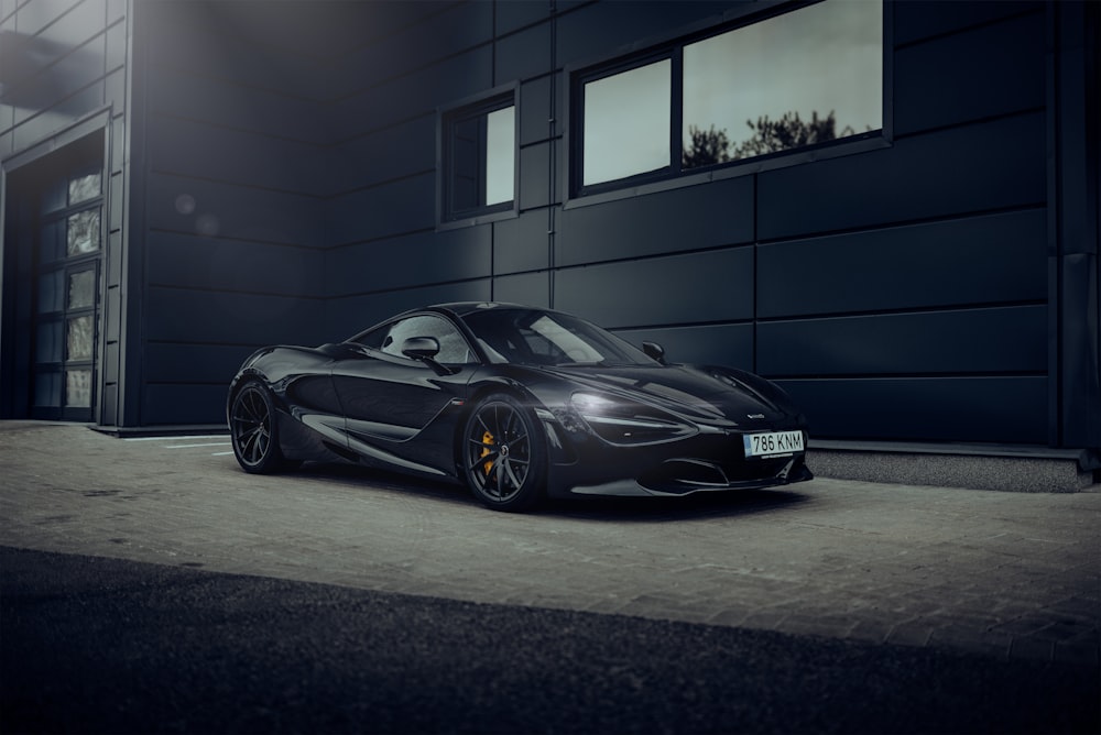 a black sports car parked in front of a garage