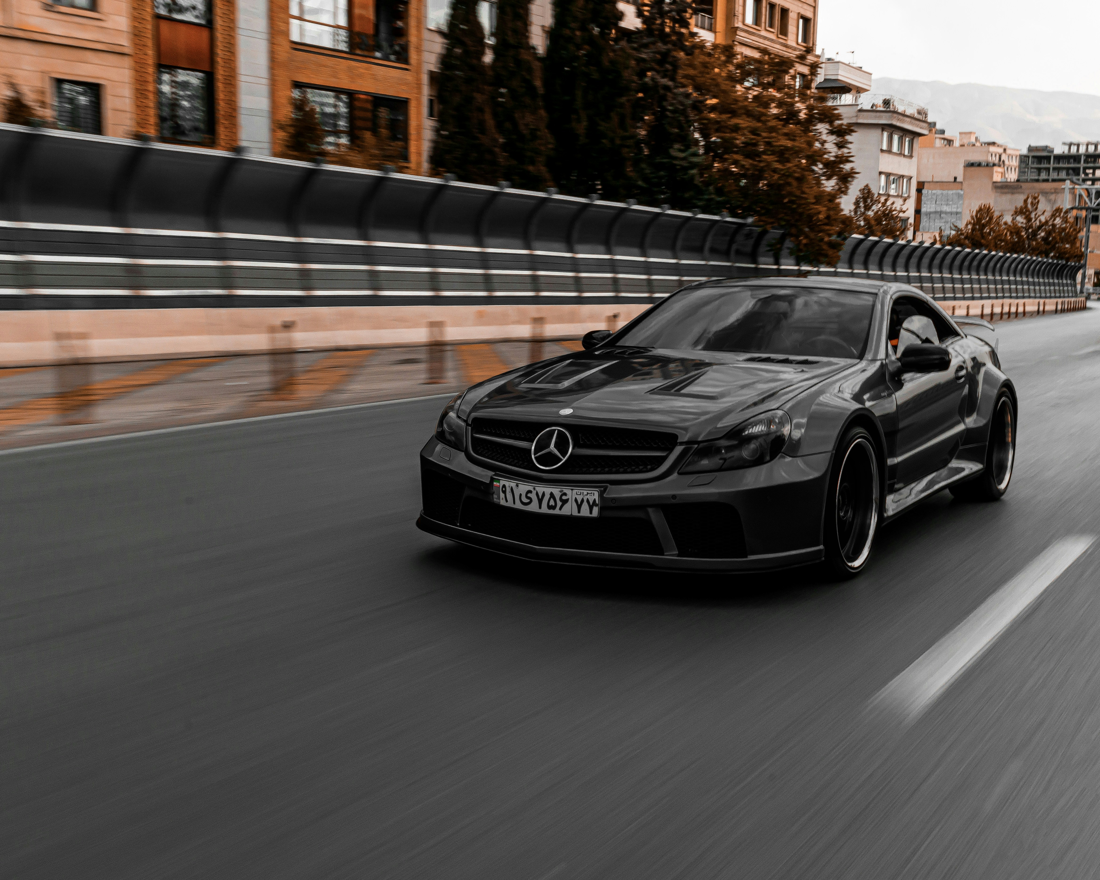 a black sports car driving on a road