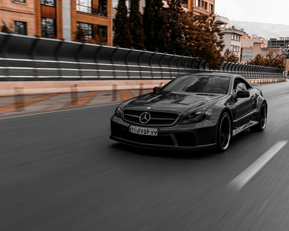 a black sports car driving on a road