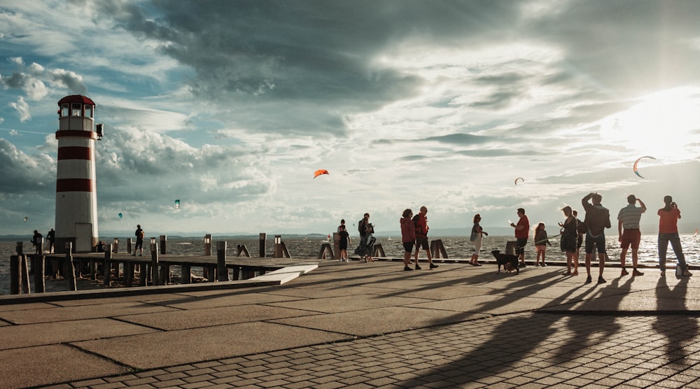 people flying kites on a pier