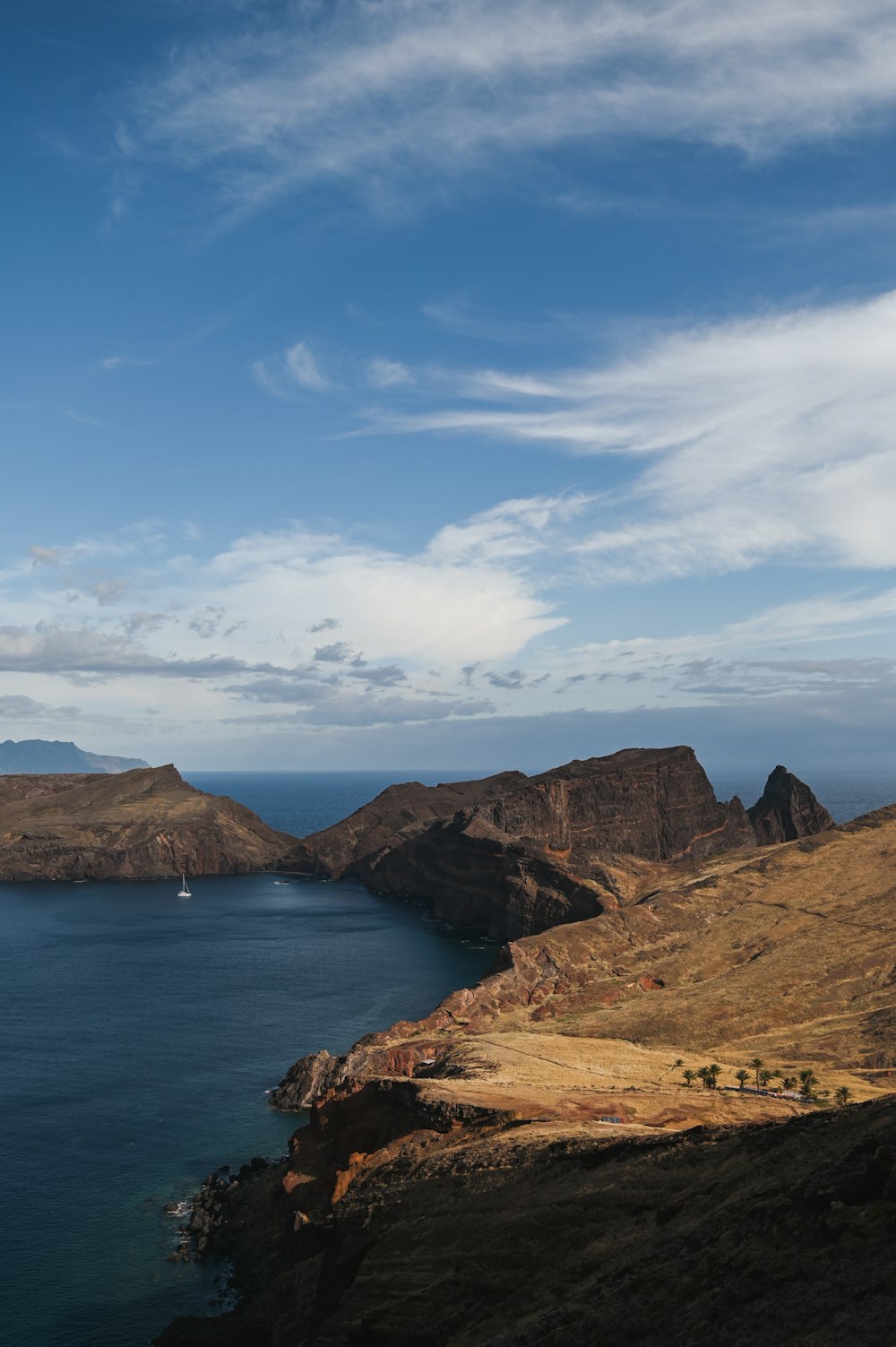 a body of water with a rocky shoreline and a boat in it