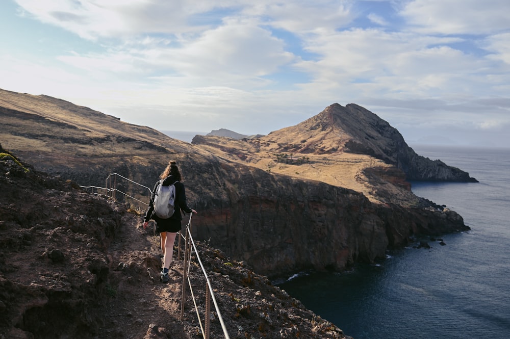 a person standing on a cliff above water