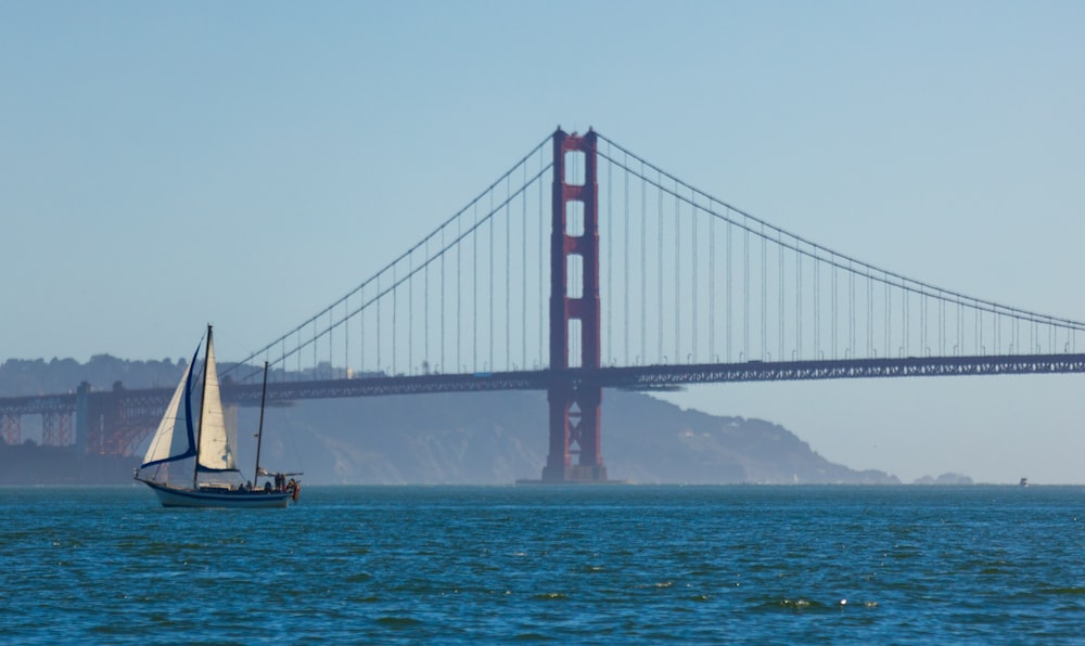 a boat sailing under a bridge