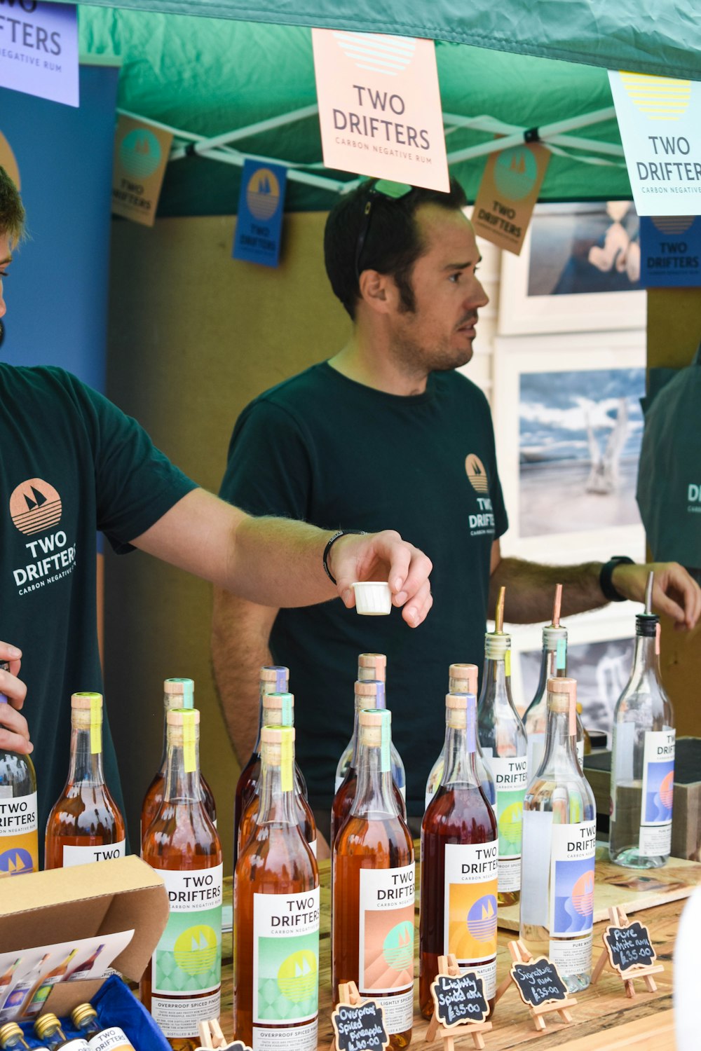 a person standing next to a table full of bottles