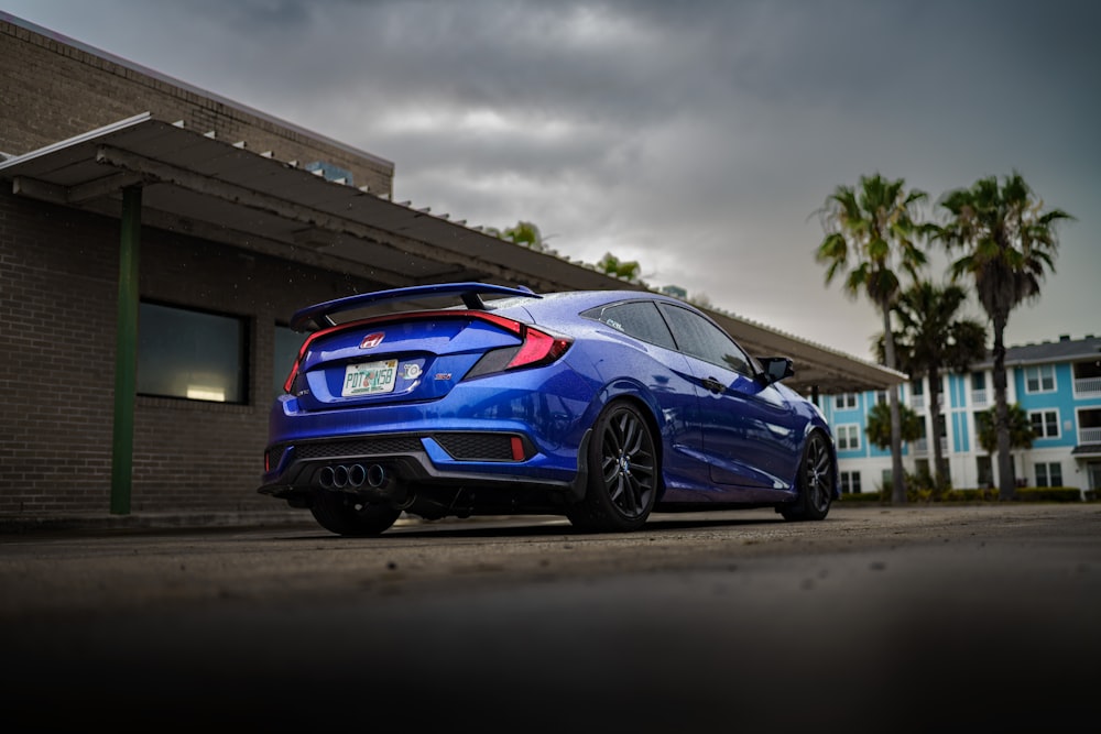 a blue car parked outside a building