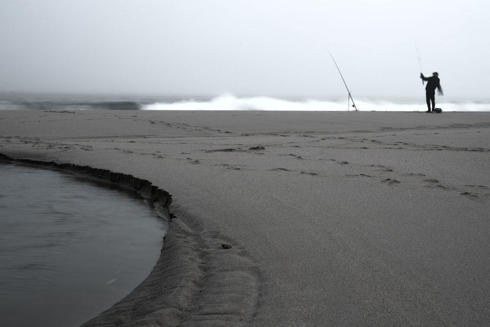 a person on a beach holding a fishing pole