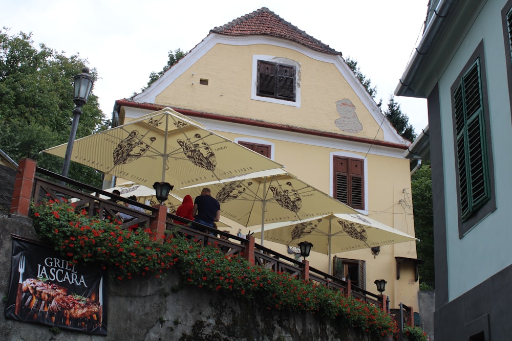 Une maison jaune avec un grand parasol