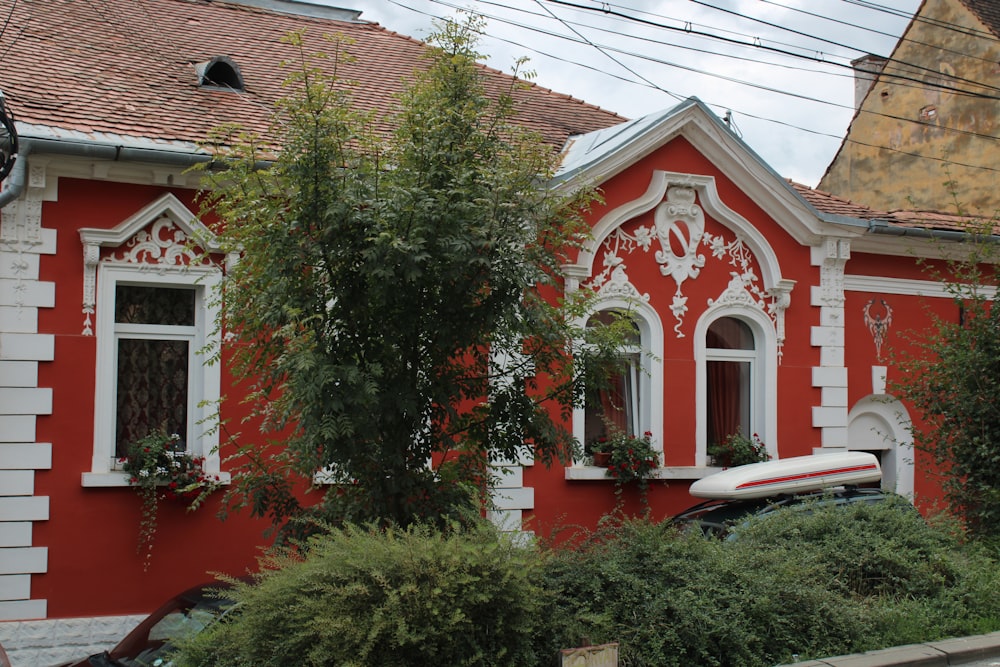 a red house with a tree in the front
