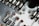 A close-up view of a circuit board showing metallic tracks, solder points, and various electronic components. The image highlights the intricate design and small details of the board with a combination of silver, copper, and greenish tones.