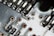 A close-up view of a circuit board showing metallic tracks, solder points, and various electronic components. The image highlights the intricate design and small details of the board with a combination of silver, copper, and greenish tones.