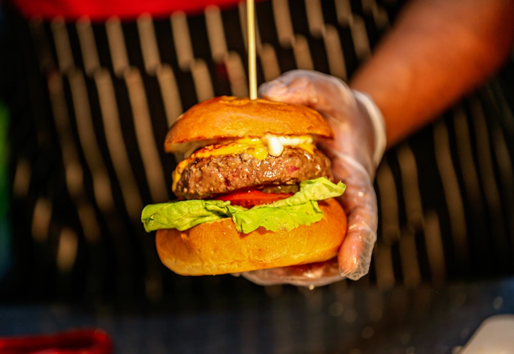 a person holding a burger