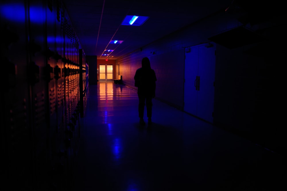 une personne marchant dans une pièce sombre