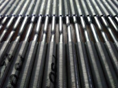 Rows of finished metallic 3D printed parts neatly arranged in an industrial setting.