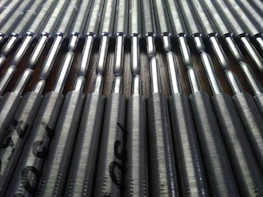 Rows of finished metallic 3D printed parts neatly arranged in an industrial setting.