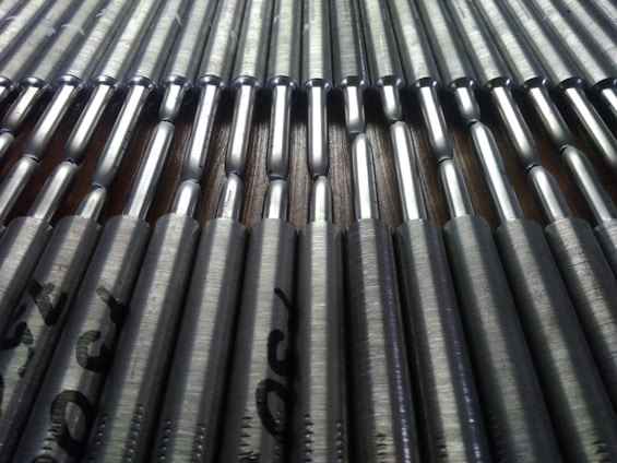 Close-up of shiny, high-quality TMT bars stacked at a manufacturing facility under bright light.