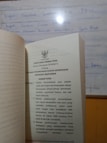 A book is open to a page containing text in Indonesian about press regulations, with a blurred whiteboard in the background. The text discusses issues concerning press freedom and the safety of journalists.