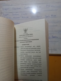 Close-up of a legal book with Indonesian emblem on the cover.