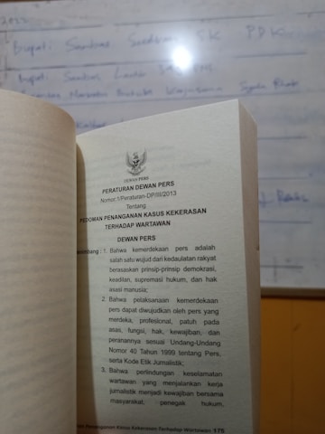 Close-up of a legal book with Indonesian emblem on the cover.