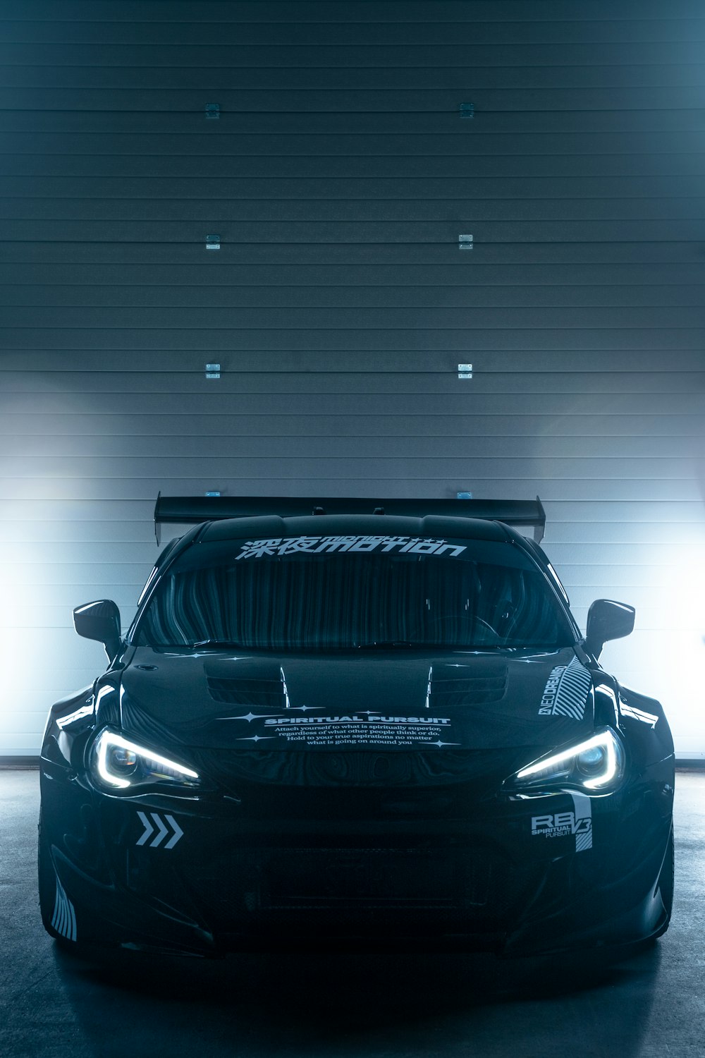 a black car parked in front of a garage