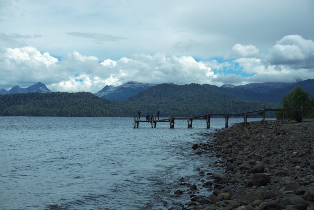 a group of people walking on a dock over a body of water