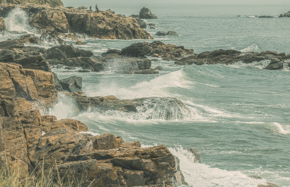 a rocky beach with waves crashing against the shore