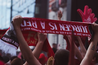 Fans celebrating together with scarves and jerseys after a match.
