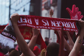 Fans celebrating together with scarves and jerseys after a match.