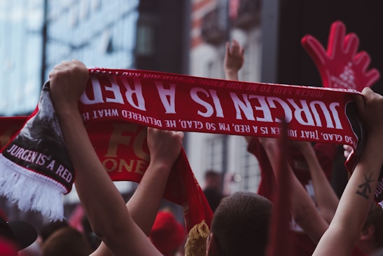 Close-up of passionate supporters in section 11 singing and cheering with scarves raised.