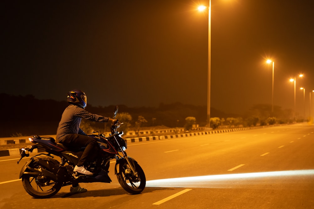 a person riding a motorcycle on a road at night
