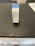 A box labeled 'FreshWater Phosphate Test Strips' with a hanging tab is placed on a dark, textured surface. The box is primarily white with blue accents and text.