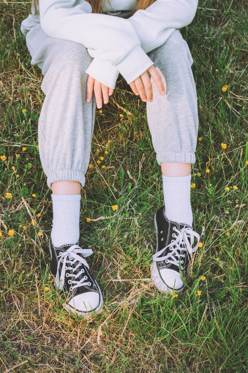 a person's legs and feet in a grassy area