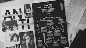 Various magazine pages are scattered, featuring black and white photographs of punk musicians performing, overlaid with bold text headers. One page prominently features the phrase 'Punk Will Eat Itself' and includes a flowchart of ideas and text regarding political and musical revolution. The overall layout is dynamic and visually engaging.