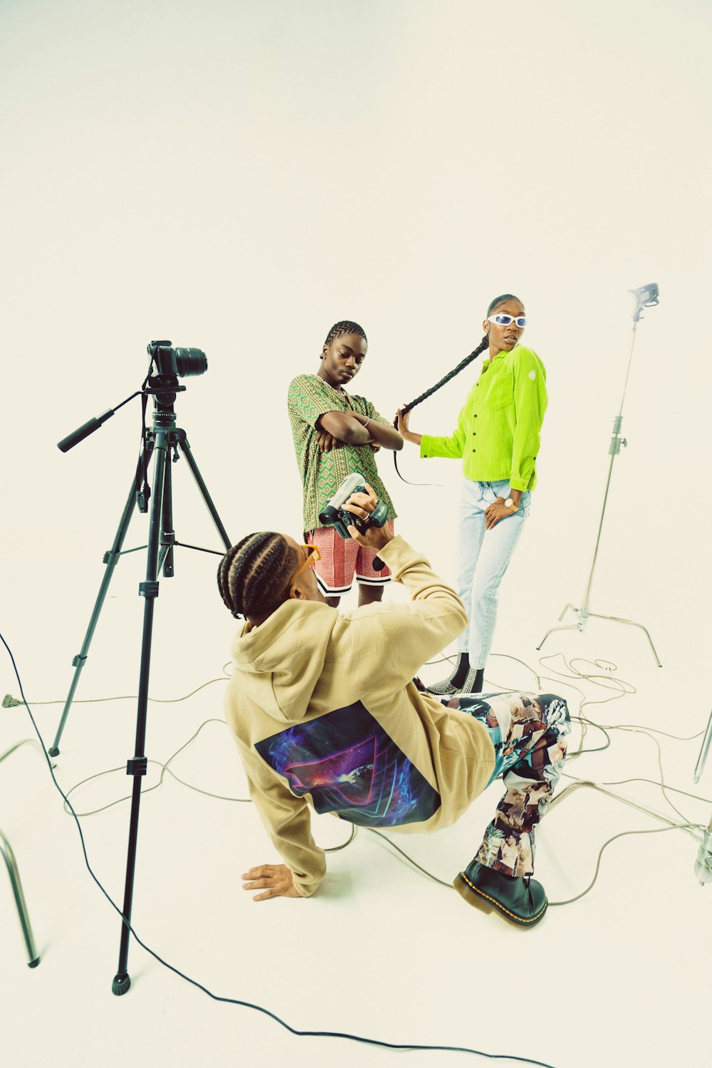 a man standing on a tripod with a man sitting on the ground