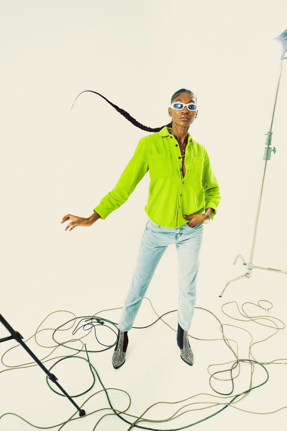 a man wearing sunglasses and a green shirt jumping on a rope