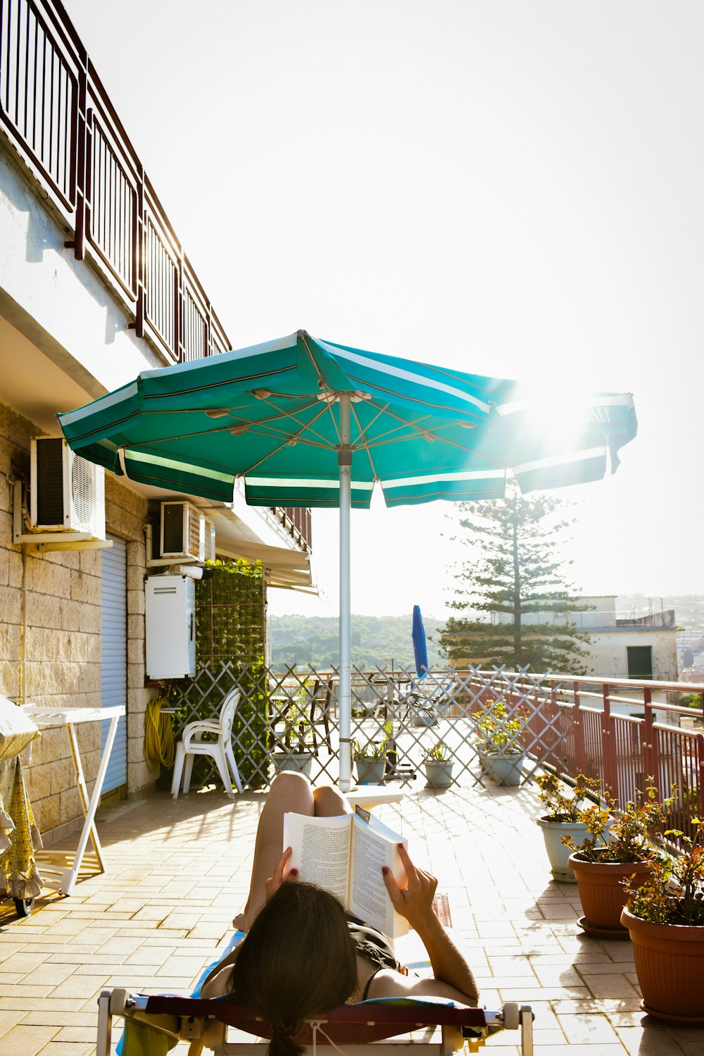 une personne lisant un livre sur une terrasse