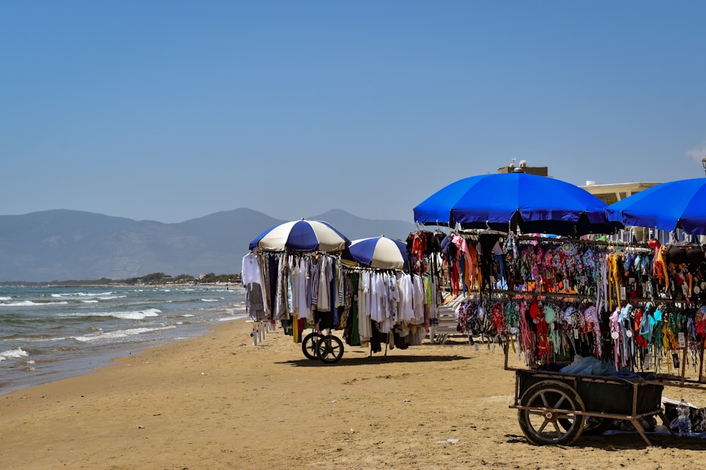 a beach with umbrellas and clothes