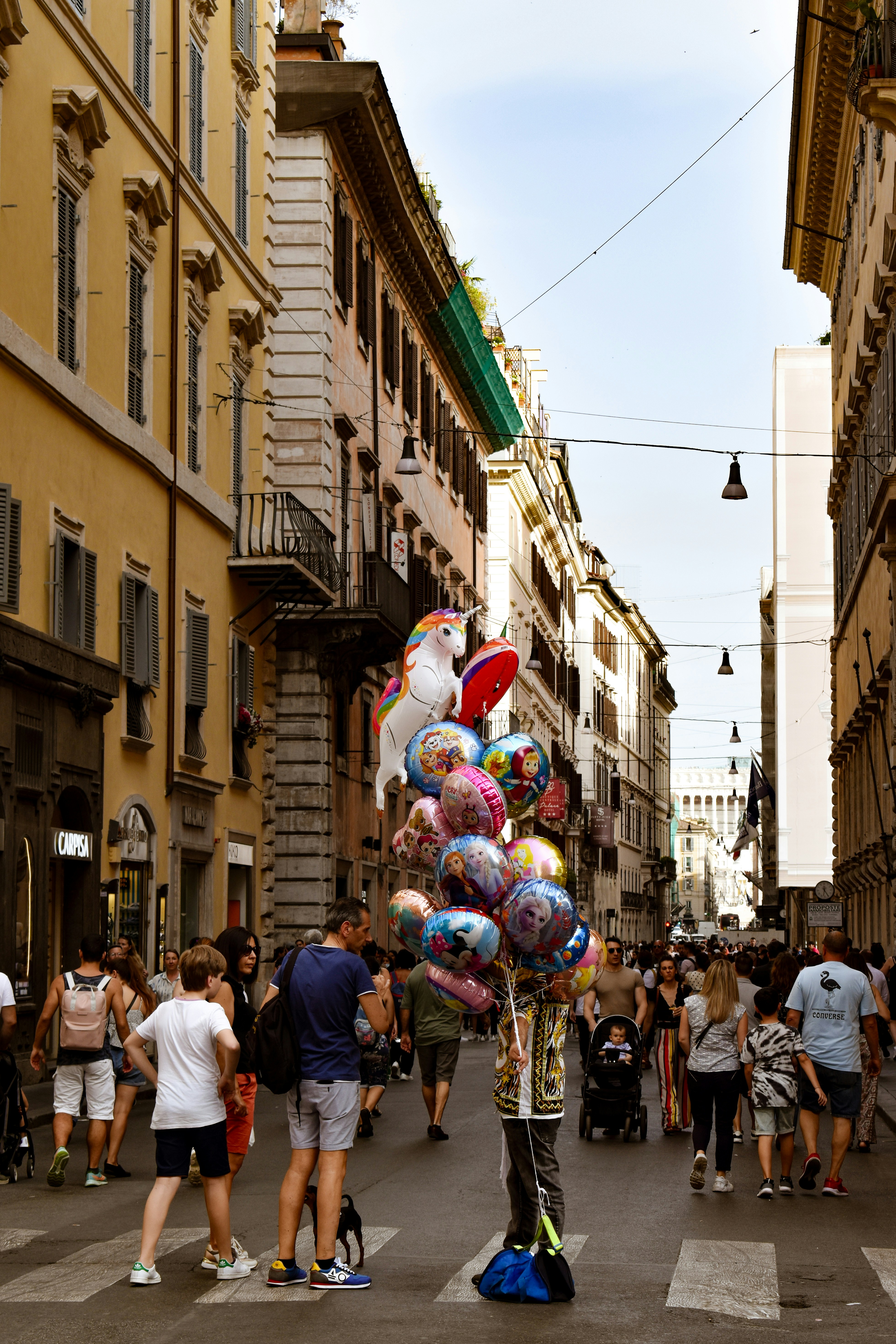 a group of people walking down a street with balloons on their heads