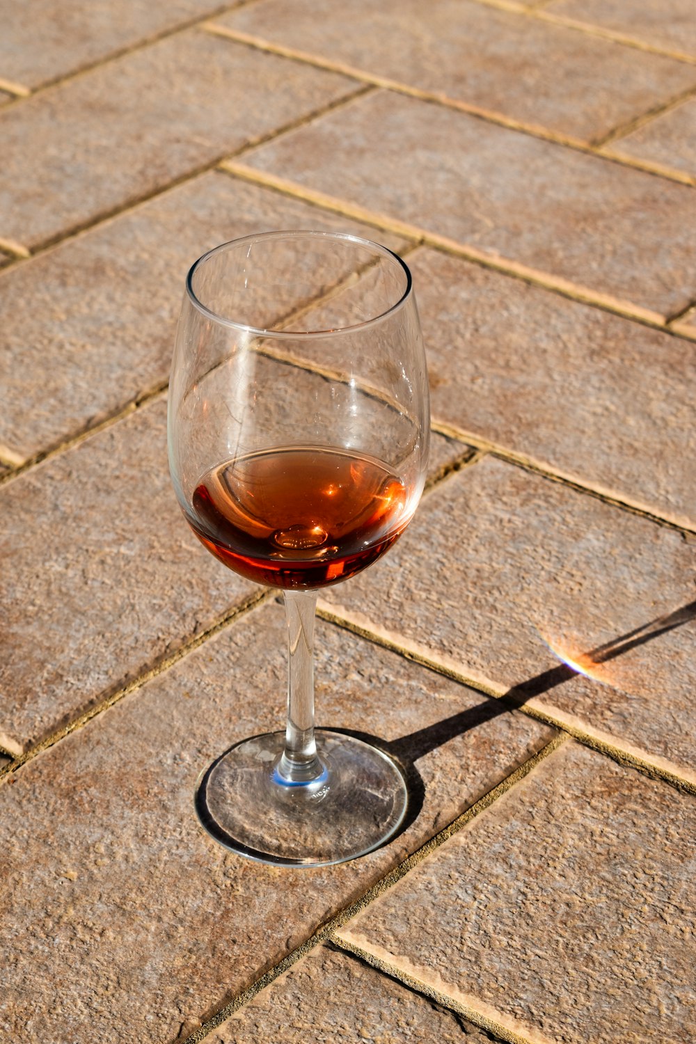 a glass of wine on a tile floor
