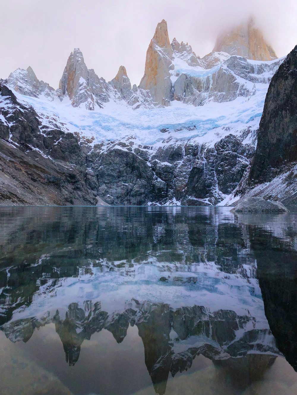 a lake with snowy mountains