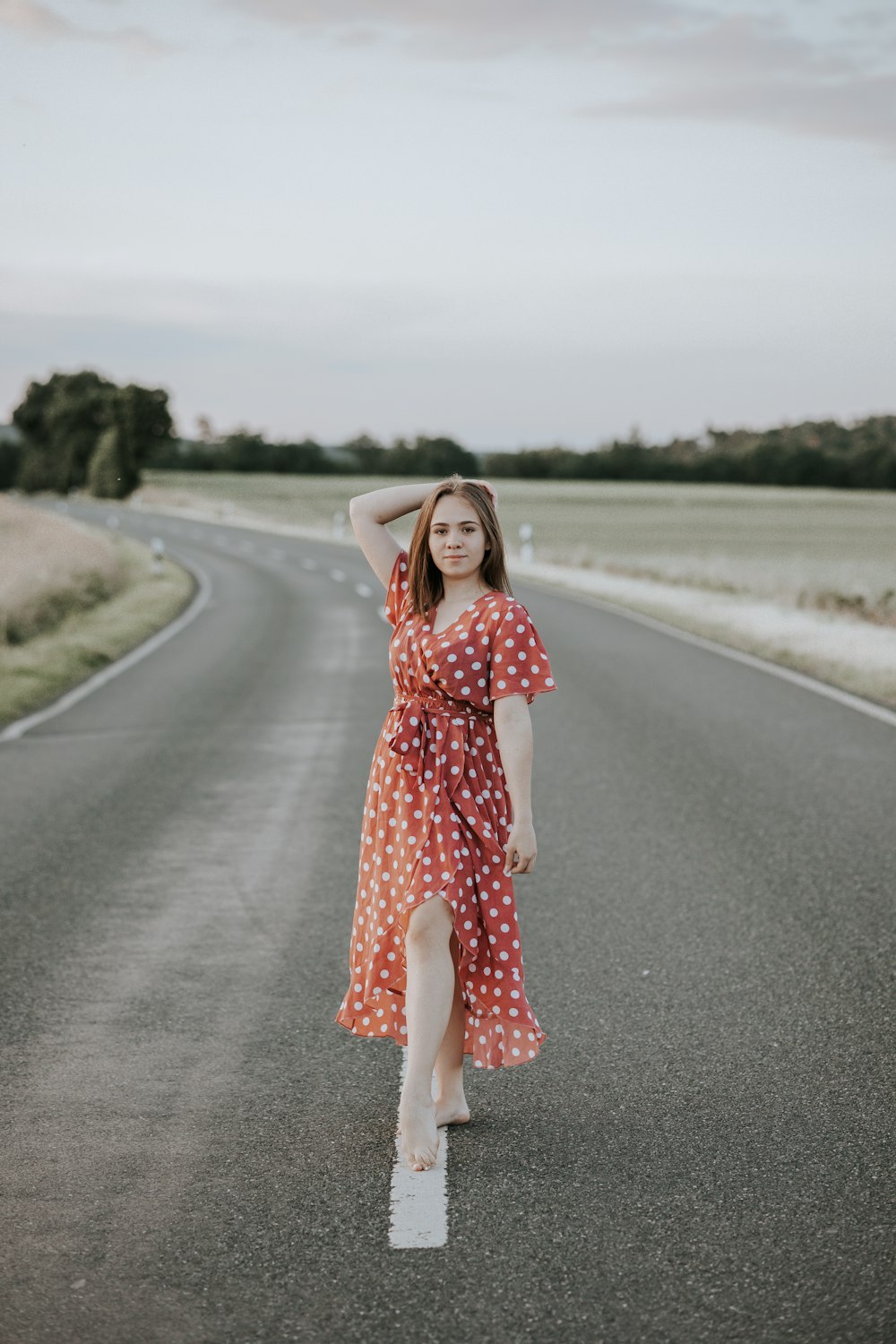 a person in a dress walking on a road