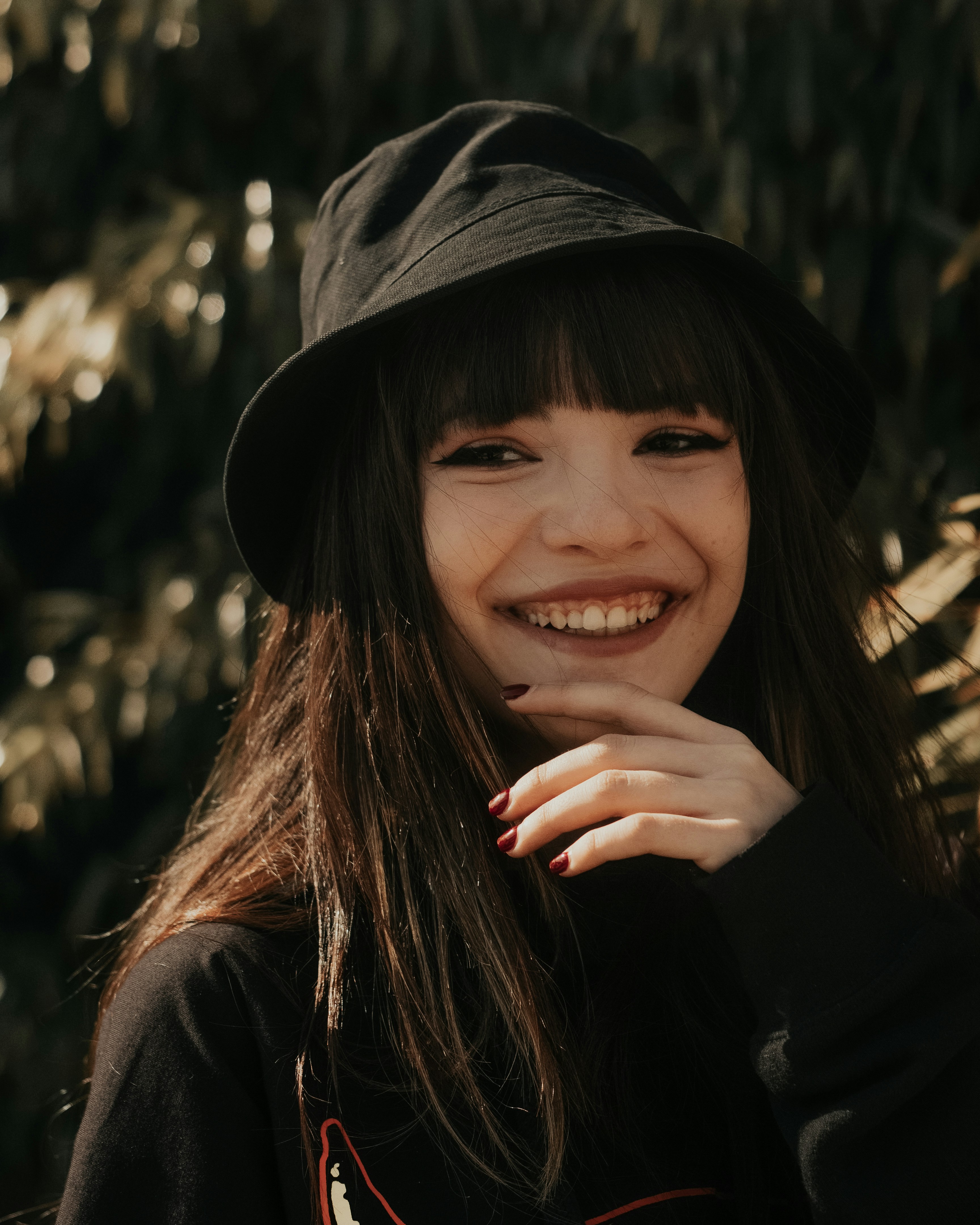 a woman smiling with her hand on her chin