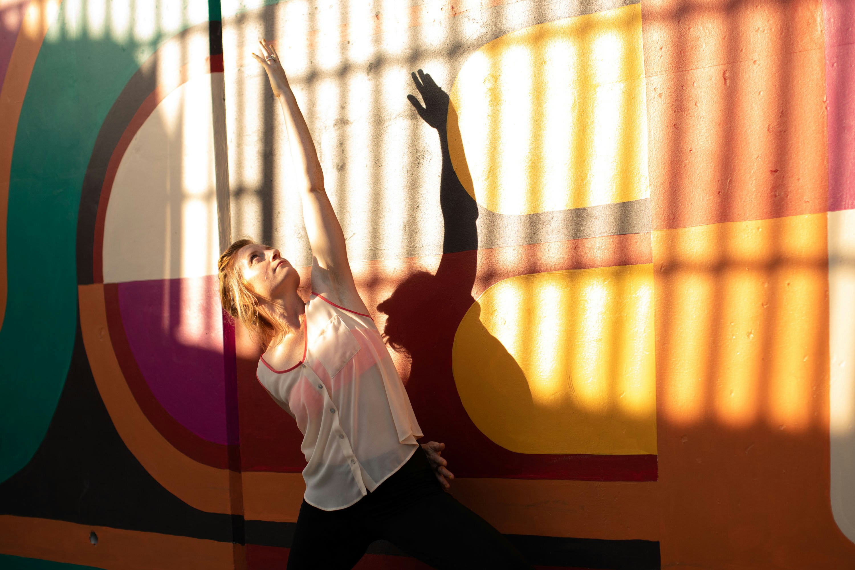 a person standing in front of a colorful wall