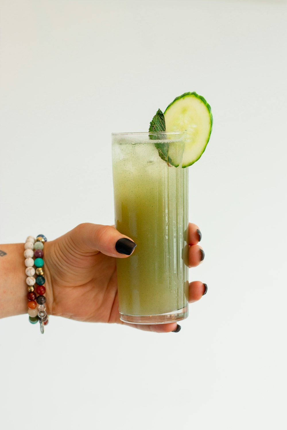 a person holding a glass with a lime slice in it