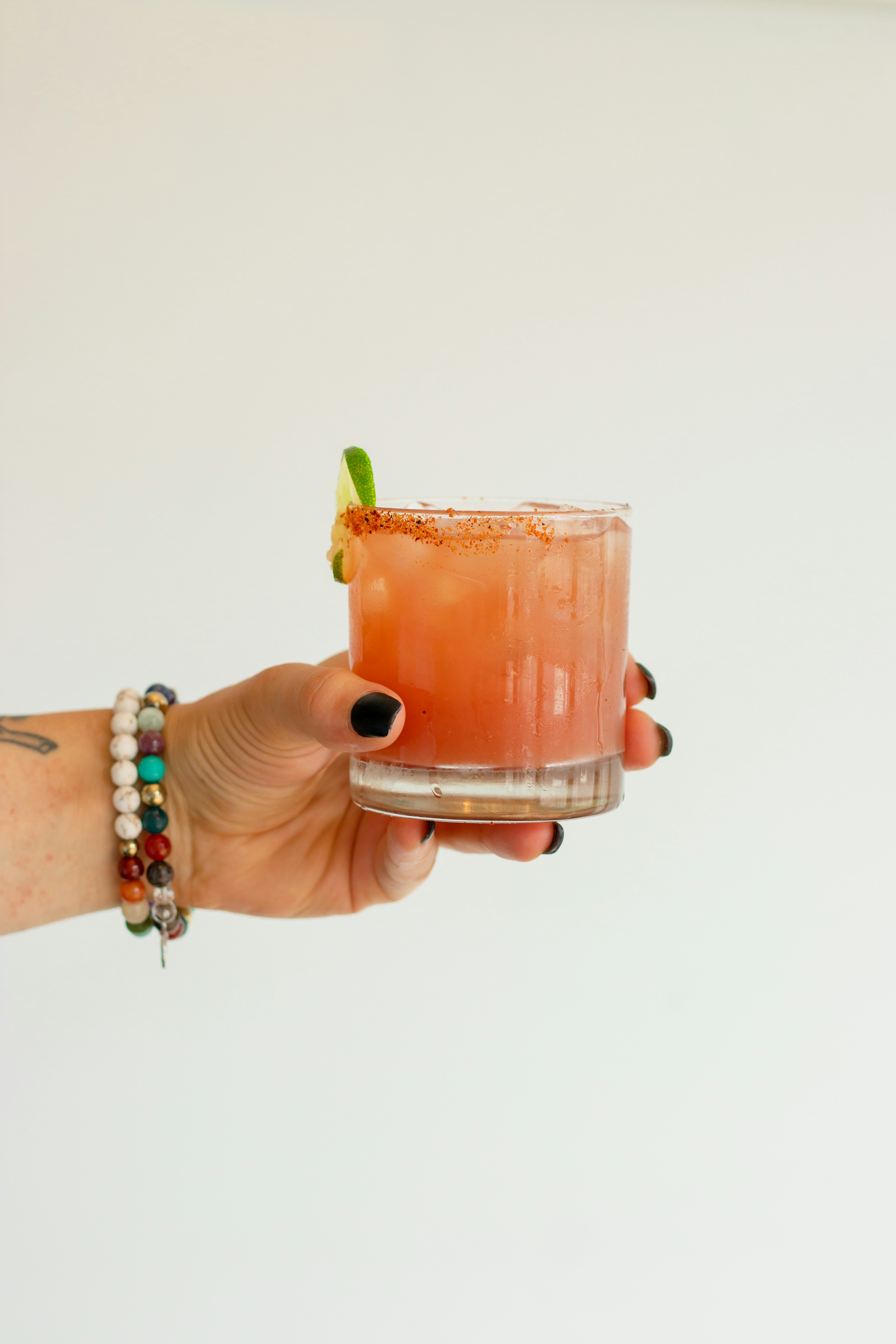 a hand holding a glass of liquid