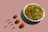 Close-up of a steaming bowl of vibrant Sichuan noodles garnished with fresh herbs.