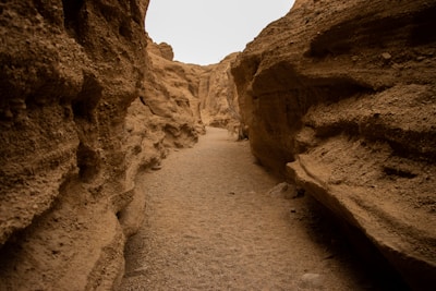 A thrilling dry canyon section with rugged rocky walls and adventurers navigating the terrain.