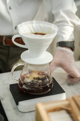 Barista carefully pouring a single-origin pour-over coffee in a minimalist setting.